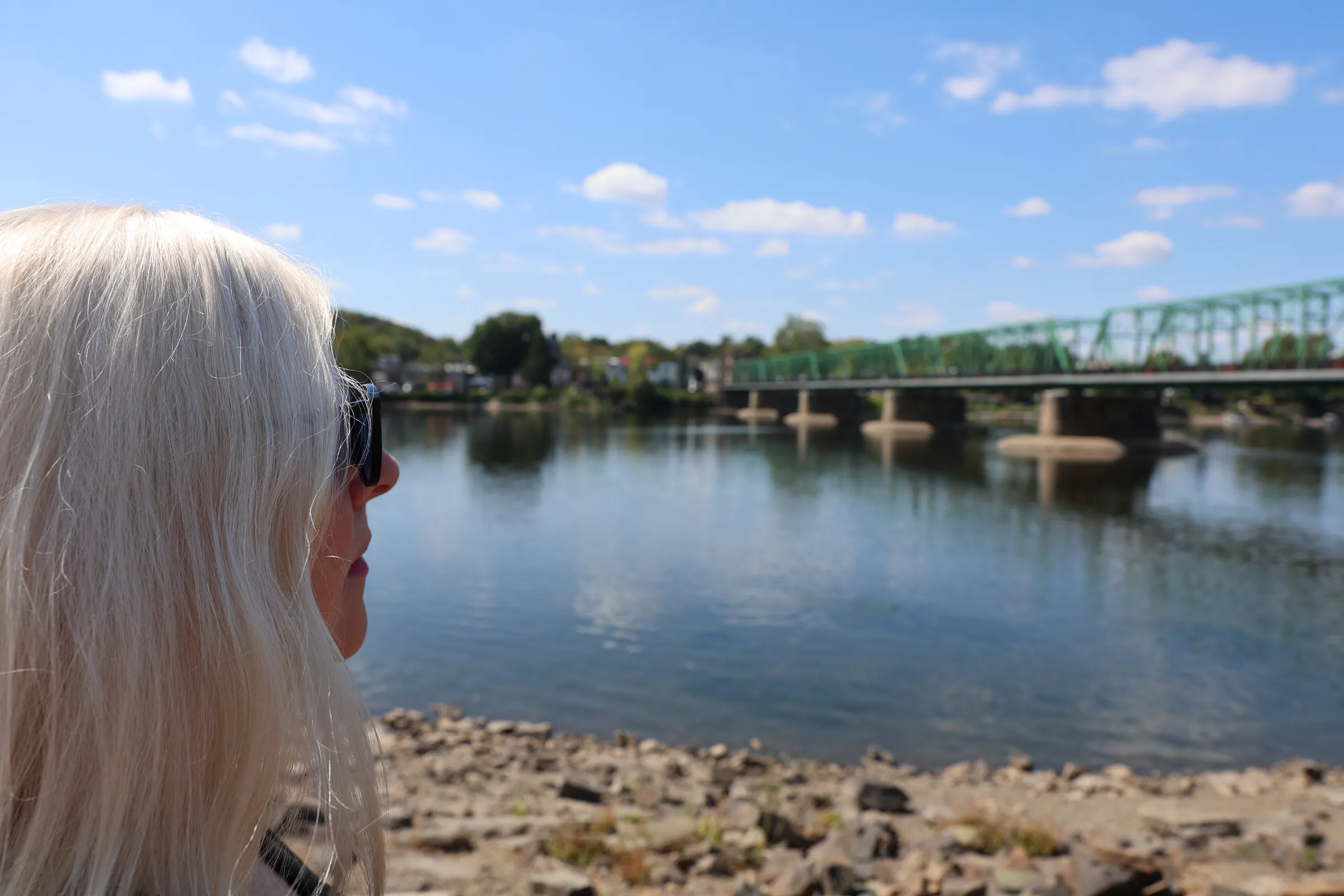 A woman looking out over a river on a bright day